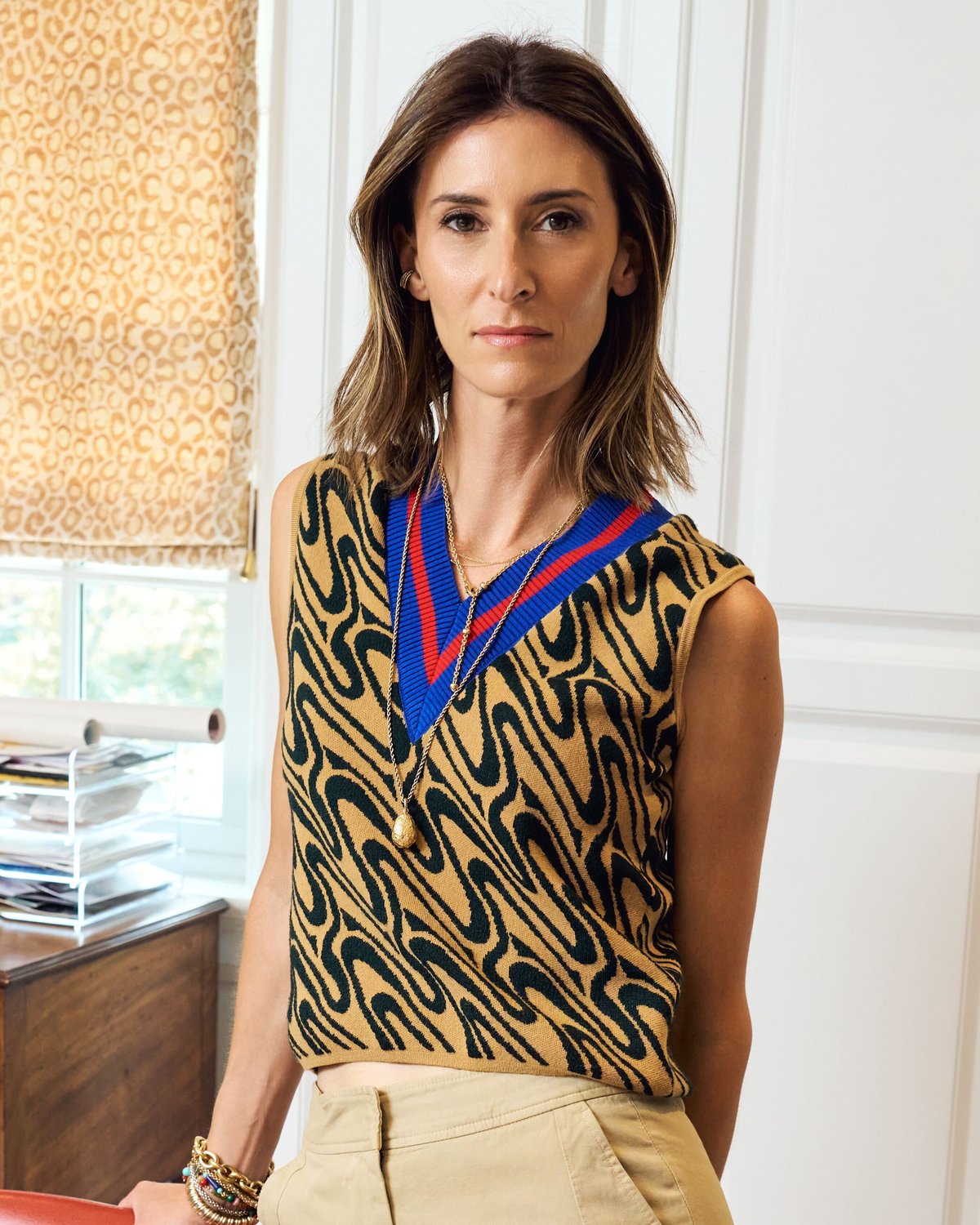 Jo Jo Whitefield standing in a doorway beside a framed geometric painting